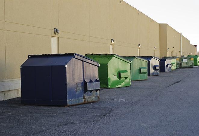 a series of colorful, utilitarian dumpsters deployed in a construction site in Alpha